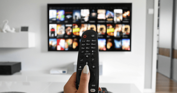 A lady controls the TV by its remote